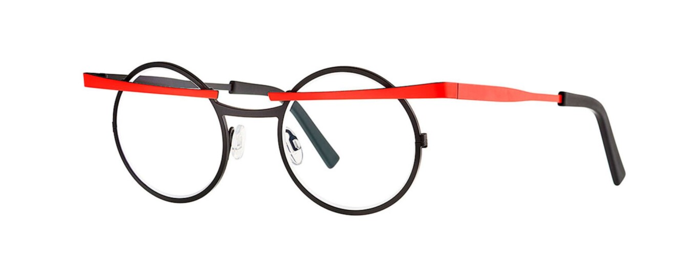 theo pagoda kolekcija Na slici se nalaze dioptrijski metalni okviri, okruglog oblika crne boje preko kojih prolazi crvena ravna crta u gornjem dijelu okulara. Krila su crvena.